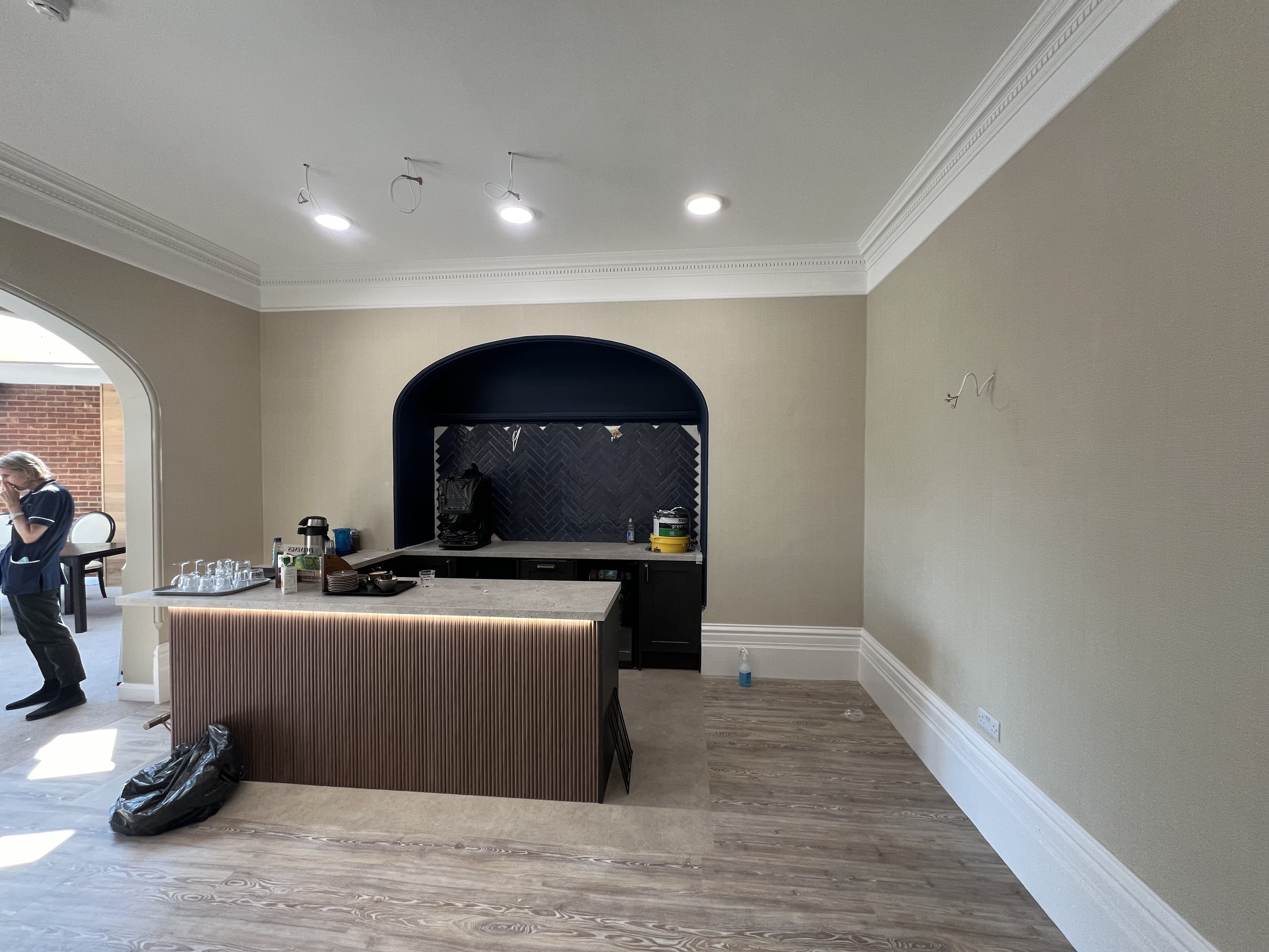 Commercial space with taupe walls, navy arched alcove, and ornate cornicing