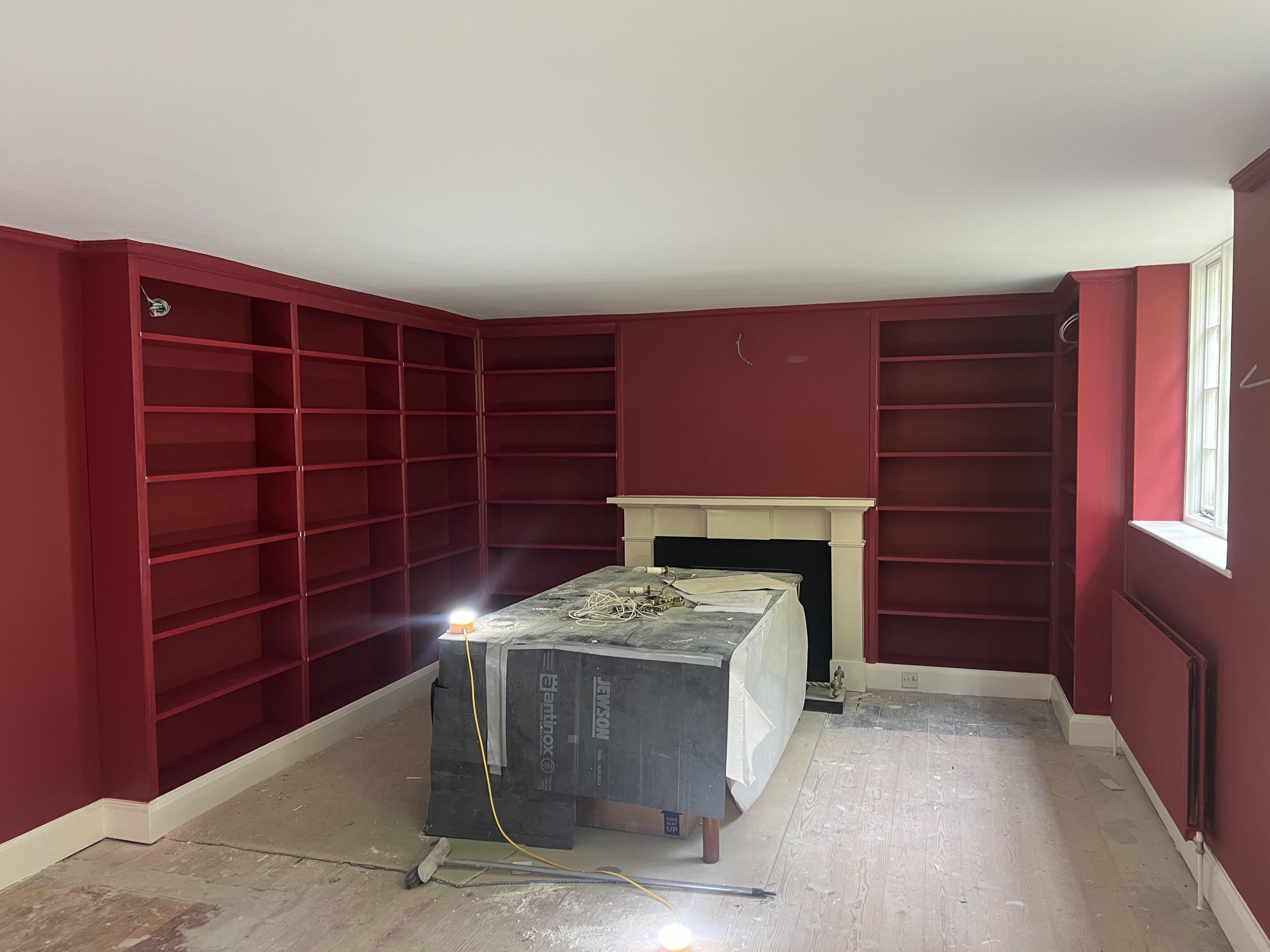 Burgundy library with built-in shelving by DecorInnovations